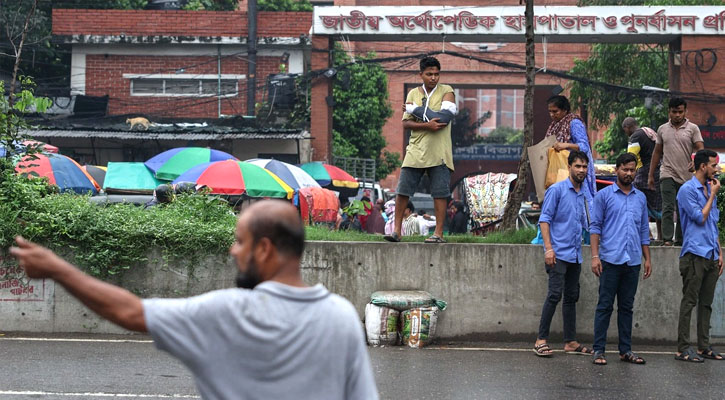 হাতে প্লাস্টার নিয়ে রাস্তা পার হতে রোড ডিভাইডারে উঠেছেন একজন রোগী